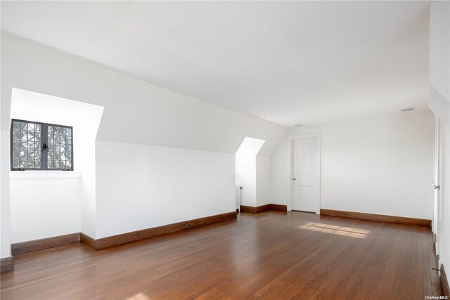 bonus room featuring lofted ceiling and dark wood-type flooring