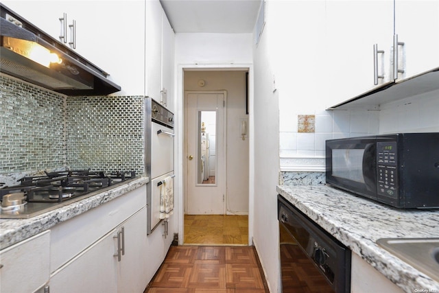 kitchen with light stone countertops, decorative backsplash, white cabinets, and black appliances