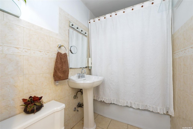 bathroom with tile patterned floors, toilet, and tile walls