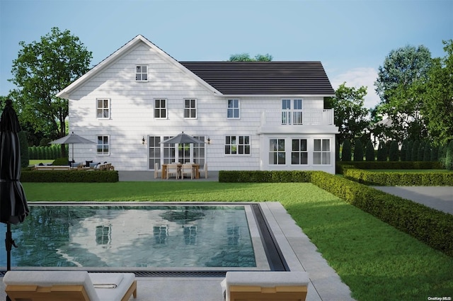 back of property featuring a yard, a balcony, and a patio area