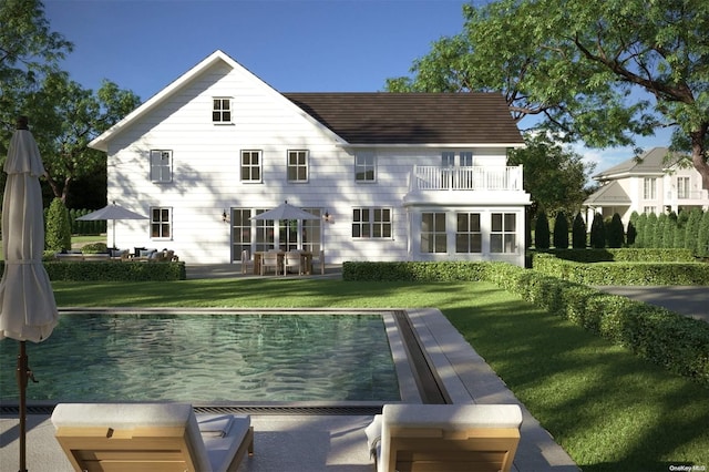 rear view of property featuring a yard, a balcony, and a patio