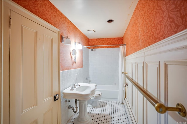 bathroom featuring shower / bathtub combination with curtain and toilet