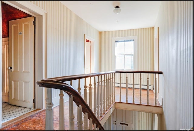 corridor featuring a baseboard radiator and hardwood / wood-style flooring