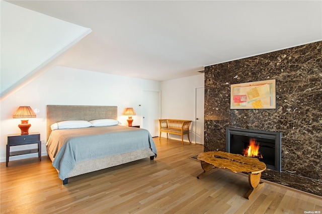 bedroom with a fireplace and wood-type flooring