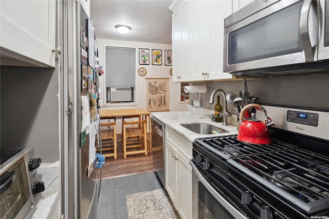 kitchen featuring sink, white cabinets, light hardwood / wood-style floors, and appliances with stainless steel finishes