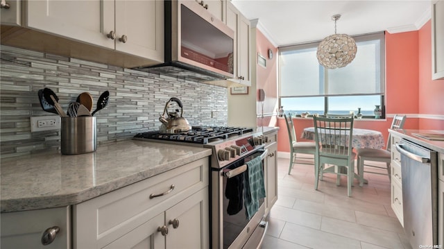 kitchen featuring pendant lighting, crown molding, decorative backsplash, light stone countertops, and appliances with stainless steel finishes