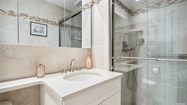 bathroom featuring vanity, tasteful backsplash, walk in shower, and tile walls