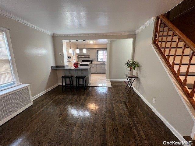 interior space with radiator, dark hardwood / wood-style flooring, and ornamental molding