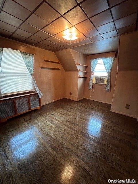 bonus room featuring wood walls, dark hardwood / wood-style flooring, and cooling unit