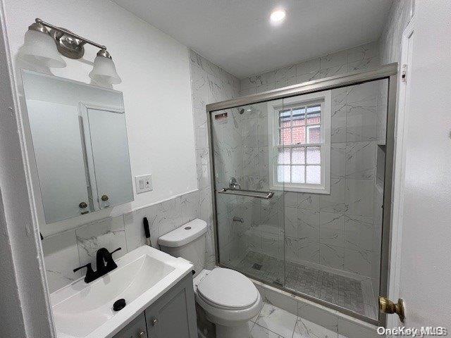 bathroom featuring vanity, toilet, and walk in shower