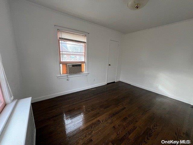 unfurnished room with cooling unit and dark hardwood / wood-style floors