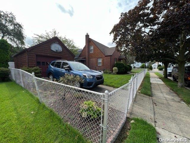 view of side of home with a yard, a garage, and an outdoor structure