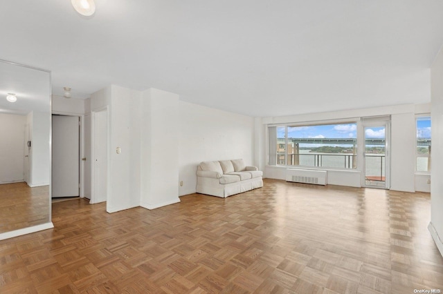 unfurnished living room with radiator and light parquet floors