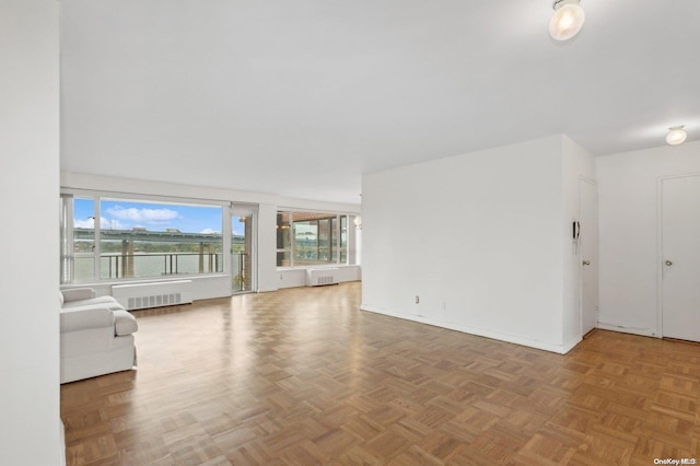 unfurnished living room with parquet flooring and radiator heating unit