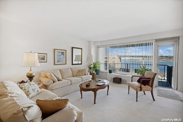 living room with a water view and light colored carpet