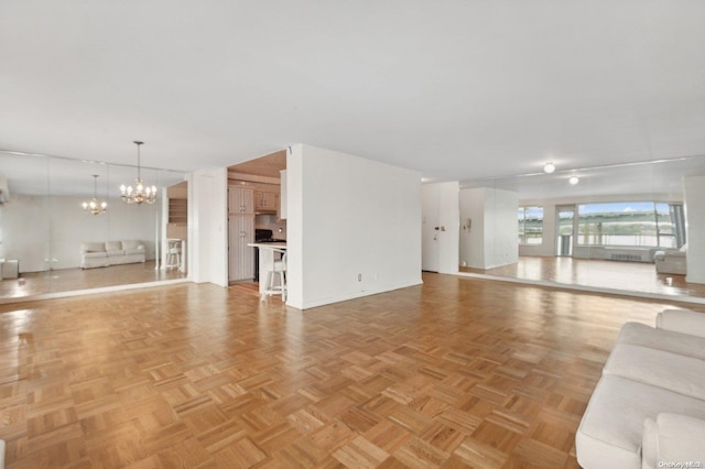 unfurnished living room featuring light parquet floors and an inviting chandelier