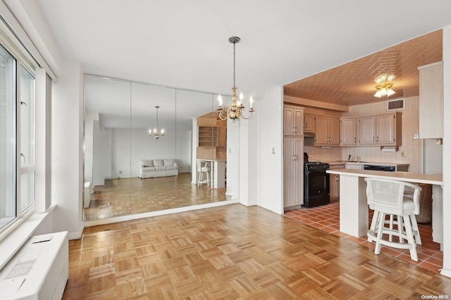 kitchen with a breakfast bar area, light parquet floors, black range, and an inviting chandelier