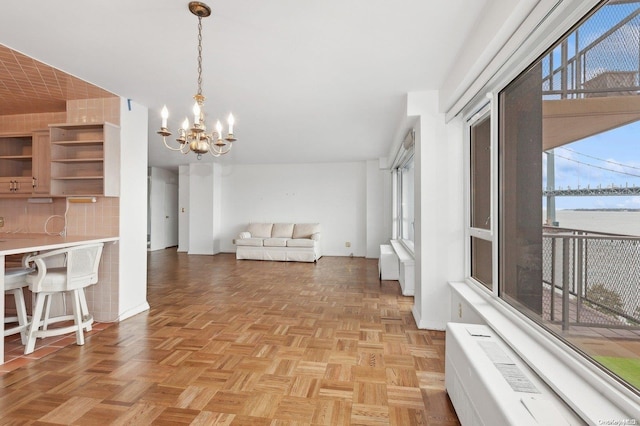 kitchen with light parquet flooring, hanging light fixtures, and an inviting chandelier