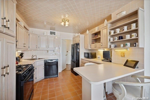 kitchen featuring kitchen peninsula, a kitchen breakfast bar, backsplash, and black appliances