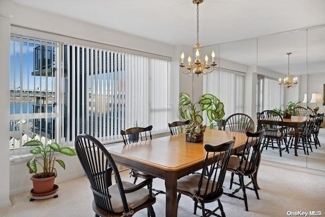 dining room featuring a healthy amount of sunlight, carpet floors, and a notable chandelier