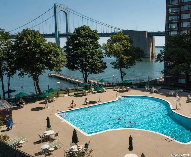 view of swimming pool featuring a patio area and a water view