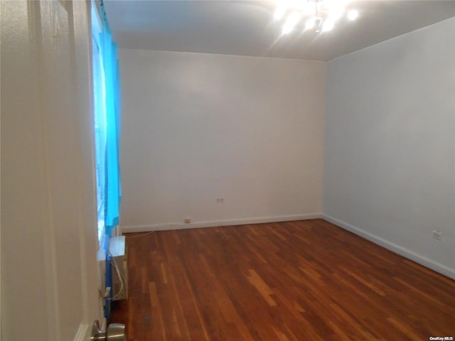 unfurnished room with dark hardwood / wood-style flooring