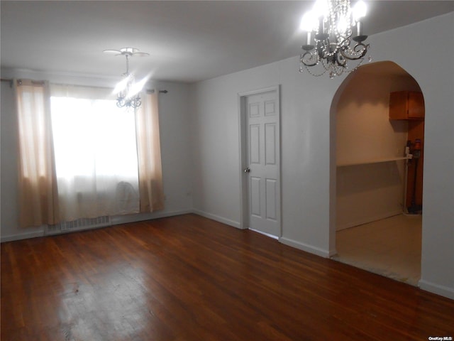 unfurnished room with dark hardwood / wood-style flooring and a chandelier