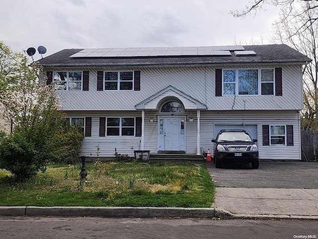 view of front of property featuring solar panels and a garage