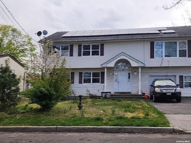 view of front of home with solar panels and a garage