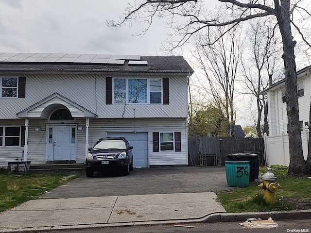 view of front of property with solar panels and a garage