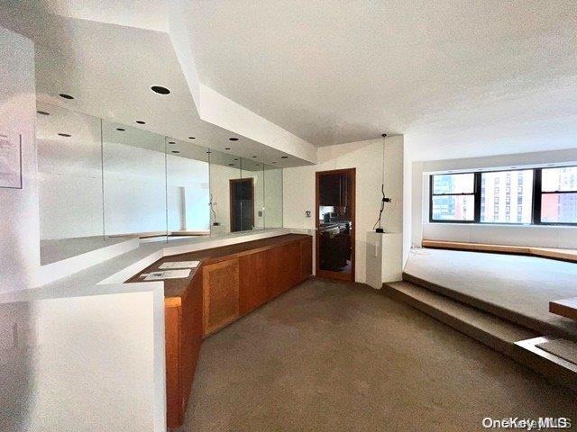 kitchen with kitchen peninsula, light carpet, and a textured ceiling