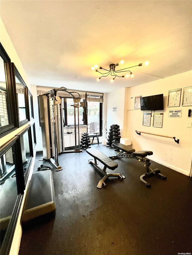 workout area featuring a textured ceiling and an inviting chandelier