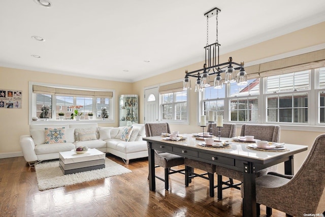 dining area featuring plenty of natural light, crown molding, dark wood-type flooring, and an inviting chandelier