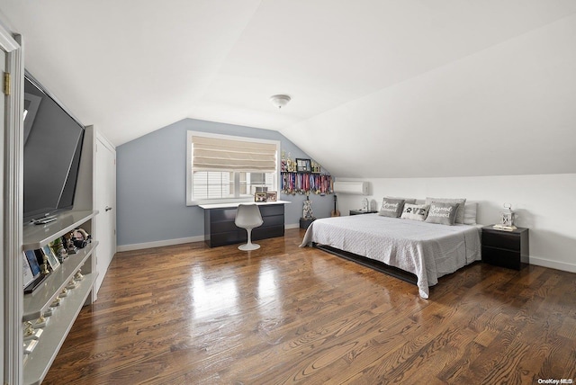 bedroom featuring dark hardwood / wood-style flooring, an AC wall unit, and vaulted ceiling