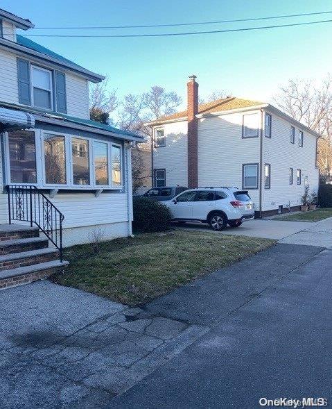 view of side of home with a sunroom and a yard