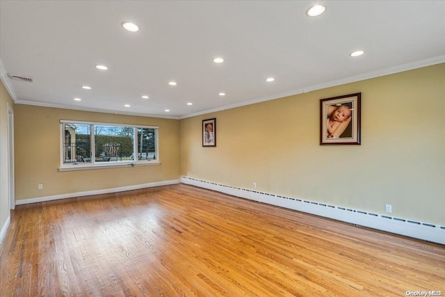 spare room featuring light hardwood / wood-style floors, a baseboard radiator, and crown molding