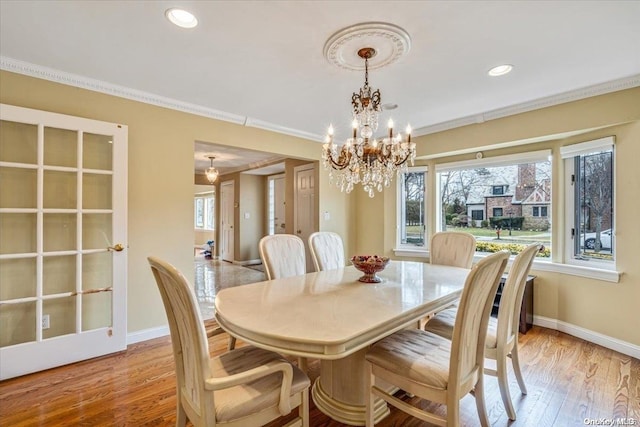 dining area featuring an inviting chandelier, light hardwood / wood-style flooring, and ornamental molding