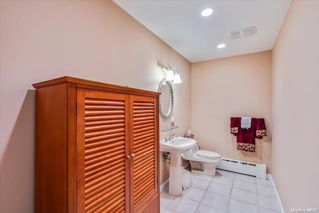 bathroom featuring tile patterned flooring, toilet, and baseboard heating