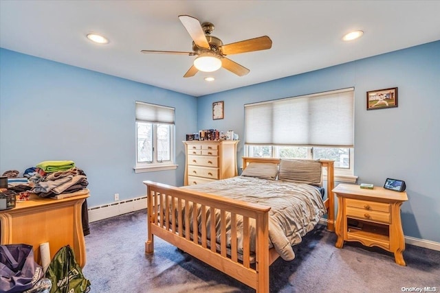 carpeted bedroom featuring multiple windows, ceiling fan, and a baseboard heating unit