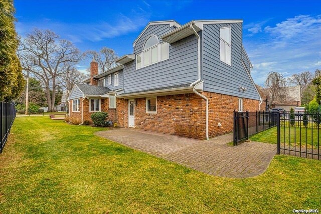 4 Midfarm Rd, Rockville Centre, NY 11570 - view of side of property featuring brick siding, a patio, and a chimney