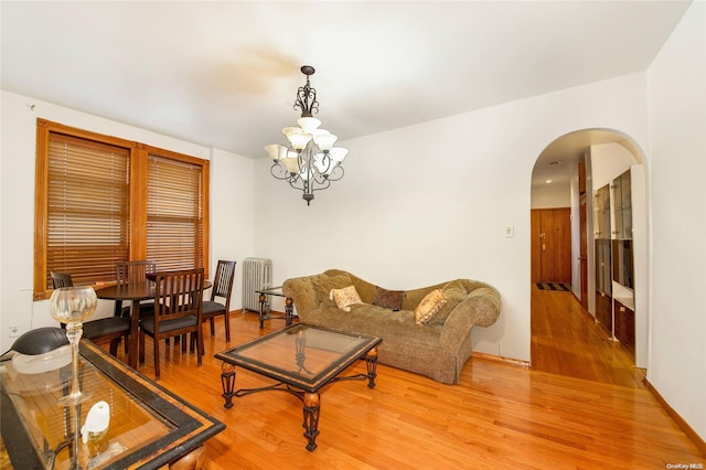 living room featuring a chandelier and light wood-type flooring