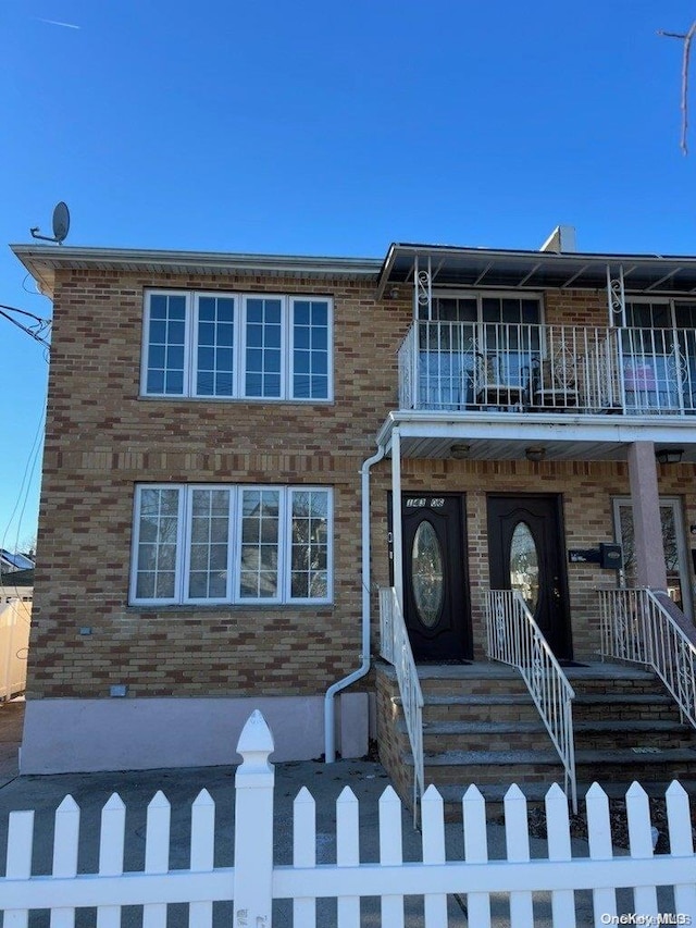 townhome / multi-family property featuring a porch and a balcony