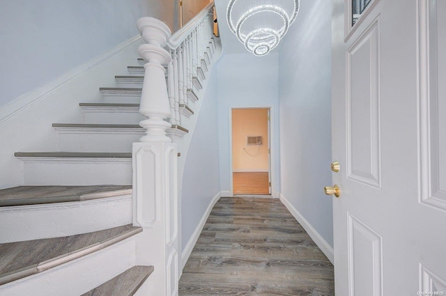 stairway featuring a chandelier and wood-type flooring