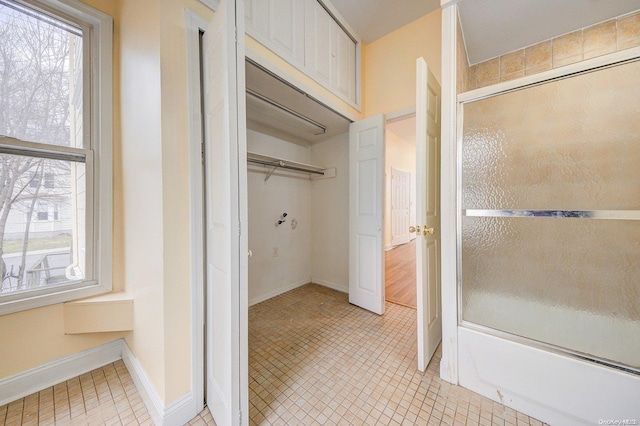 bathroom featuring tile patterned floors and bath / shower combo with glass door