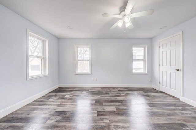 spare room featuring dark hardwood / wood-style floors, a healthy amount of sunlight, and ceiling fan