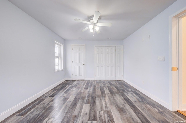 unfurnished bedroom featuring ceiling fan and dark wood-type flooring