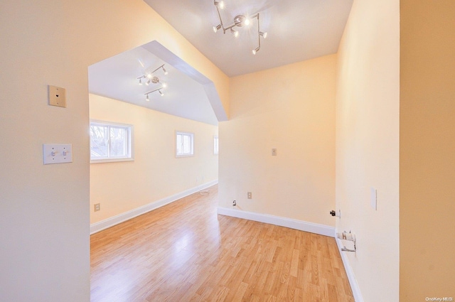 spare room with rail lighting and light hardwood / wood-style floors