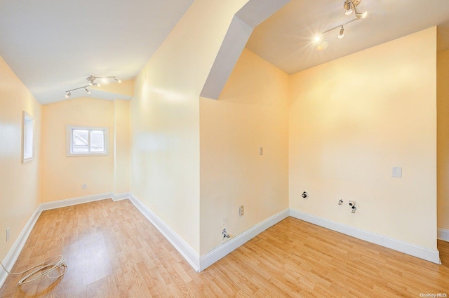 interior space featuring hardwood / wood-style floors, lofted ceiling, and rail lighting