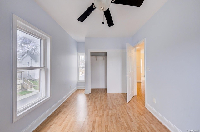 unfurnished bedroom featuring multiple windows, ceiling fan, and light hardwood / wood-style flooring