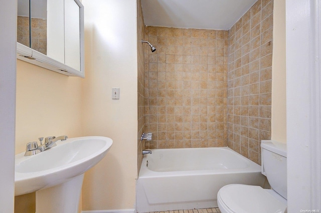 full bathroom with tile patterned flooring, tiled shower / bath combo, toilet, and sink